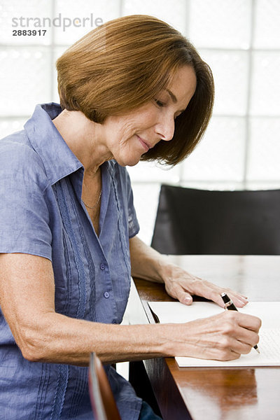 Frau schreibt in ein Notizbuch