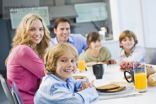 Porträt einer Familie beim Frühstücken und Lächeln