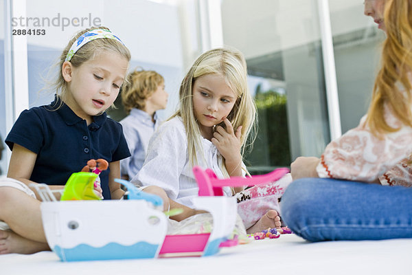 Drei Mädchen spielen mit Spielzeug