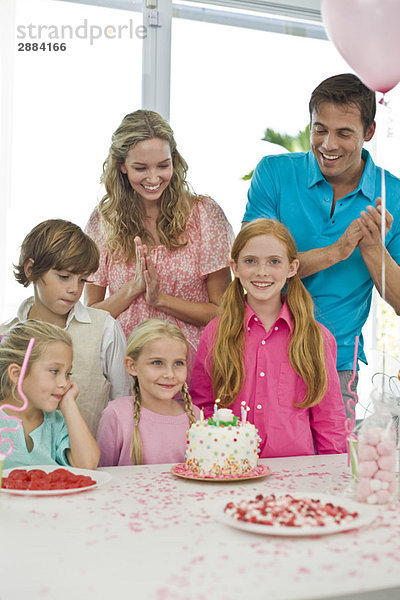 Mädchen feiert Geburtstag mit ihren Eltern und Freunden
