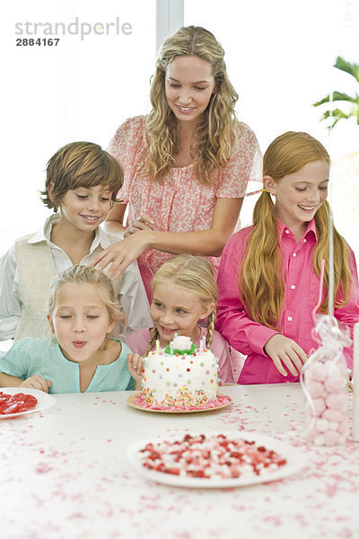 Mädchen feiert Geburtstag mit ihrer Mutter und Freunden