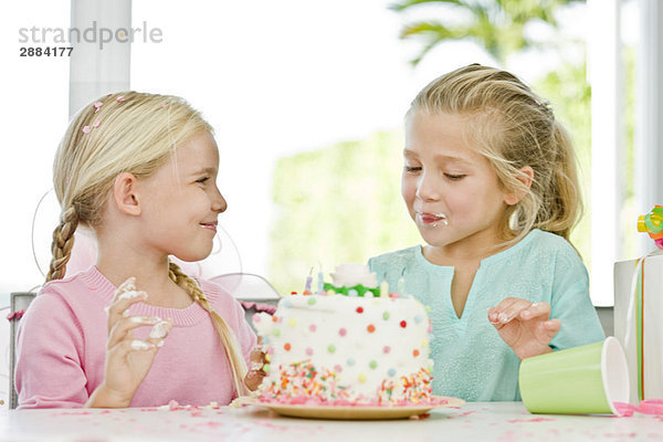 Zwei Mädchen essen Geburtstagstorte