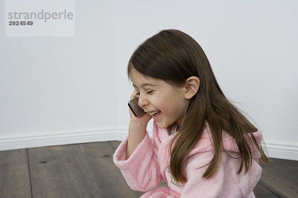 Ein junges Mädchen  das mit einem Handy spricht.