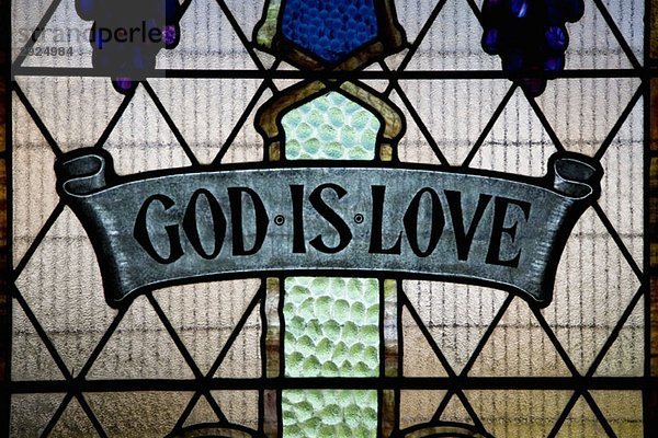 Gott ist Liebe geschrieben in einem Glasfenster