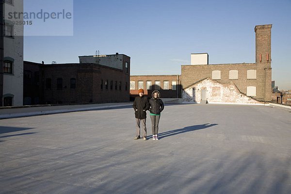 Eine Frau und ein Mann stehen auf einem Dach.
