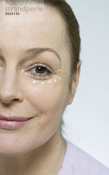 Eine Frau  die Gesichtscreme aufträgt