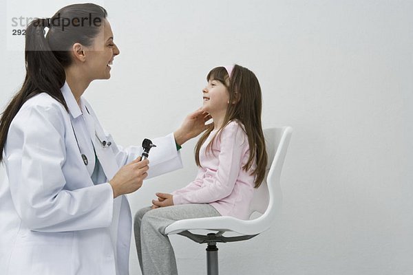 Ein Arzt  der ein Mädchen untersucht.