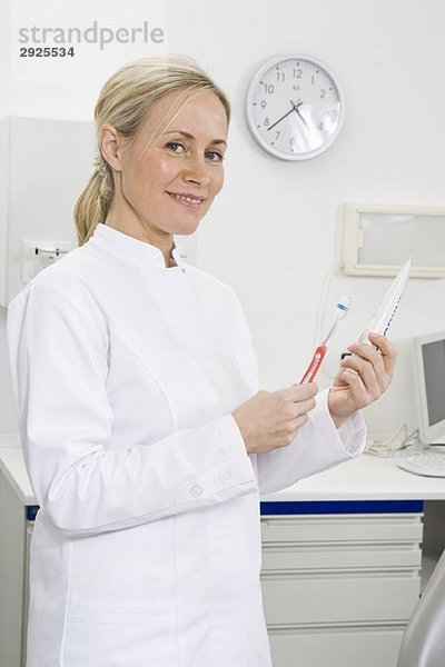 Zahnarzthelferin mit Zahnbürste und Zahnpasta