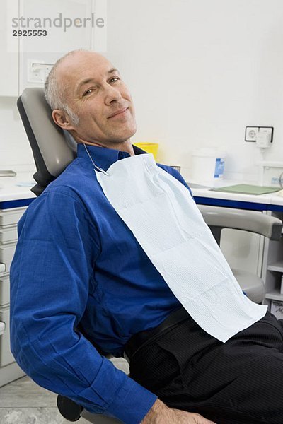 Ein Patient sitzt auf einem Zahnarztstuhl