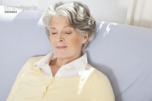 Eine ältere Frau  die auf einer Couch schläft.