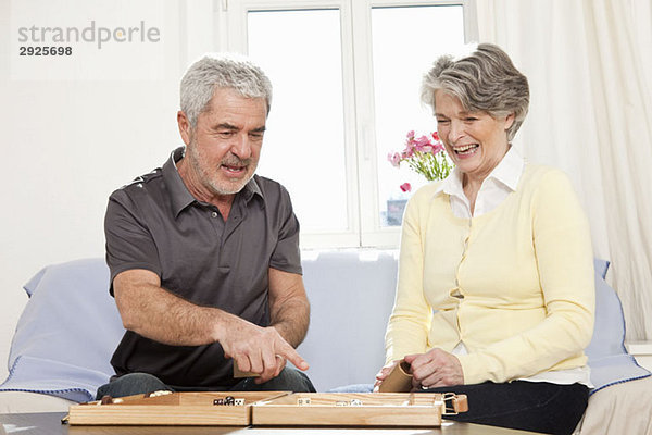 Ein älterer Mann und eine ältere Frau  die Backgammon spielen.