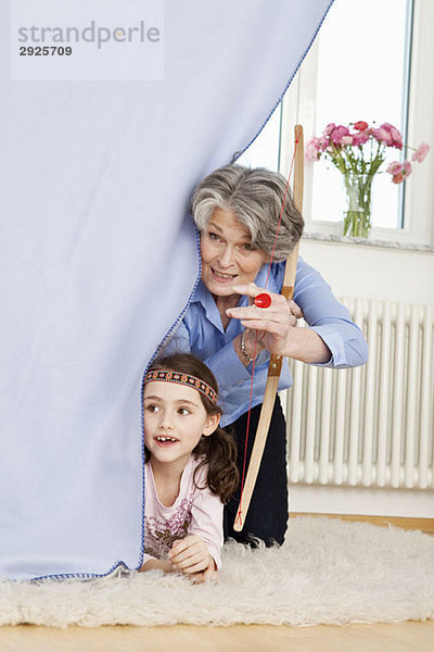 Eine Großmutter und ihre Enkelin beim Spielen lassen glauben.
