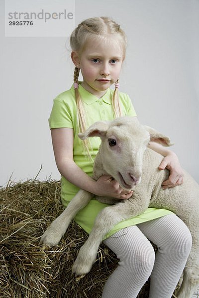 Ein Mädchen mit einem weißen Lamm  Studioaufnahme