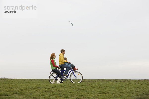 Eine junge Familie auf dem Fahrrad zusammen