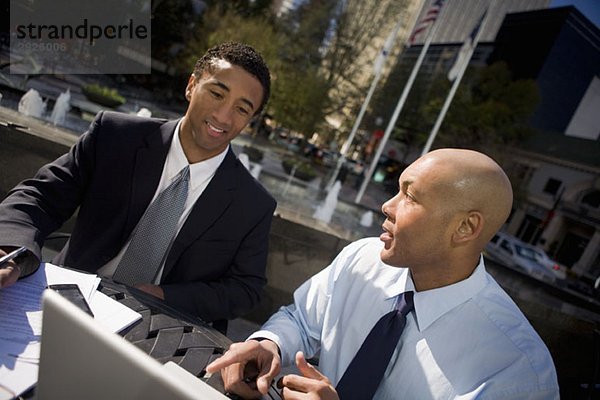Zwei Geschäftsleute reden im Freien