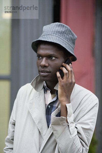 Ein junger Mann  der ein Handy benutzt.