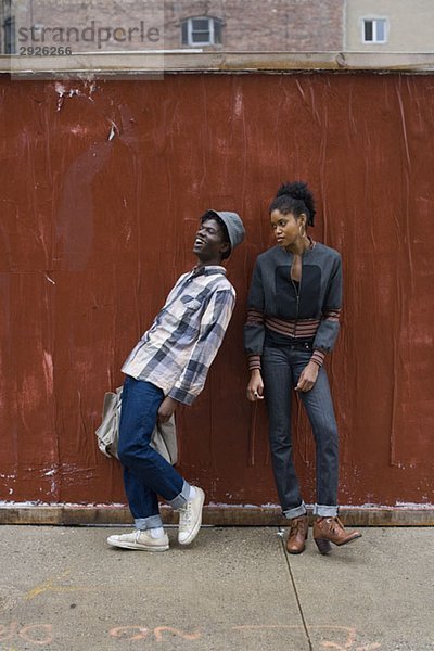 Ein junges Paar  das auf einem Bürgersteig steht.