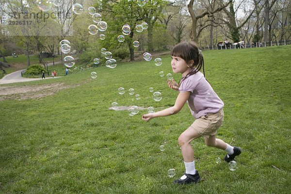 Ein junges Mädchen fängt Blasen im Central Park  New York City.
