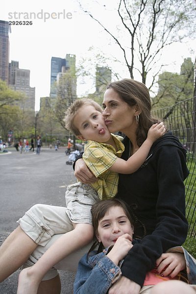 Eine Mutter sitzt mit ihren Kindern im Central Park  New York City.