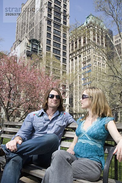 Ein junges Paar mit Sonnenbrille und gemeinsam auf einer Parkbank sitzend  Central Park  New York City