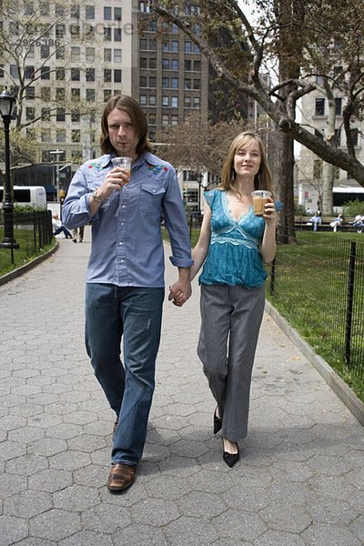 Ein junges Paar  das durch einen Stadtpark geht und Händchen hält  Central Park  New York City