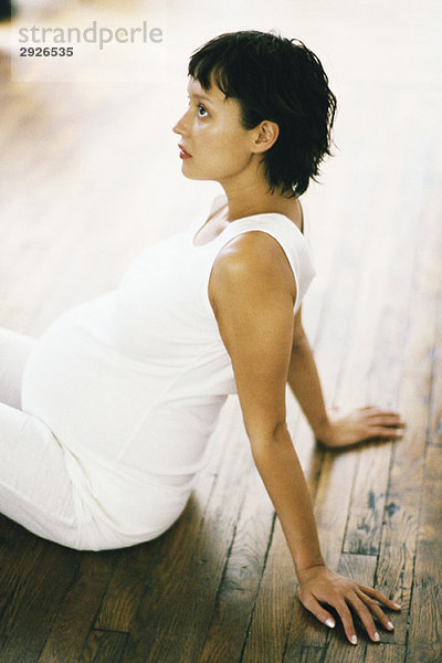 Schwangere macht Atemübungen auf dem Boden