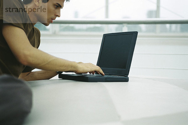 Mann auf dem Boden liegend mit Laptop-Computer