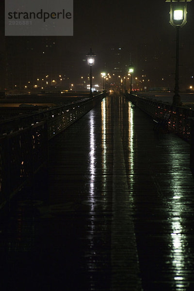 Erhöhter Fußgängerweg nass nach Regen bei Nacht  oberhalb der Brooklyn Bridge  New York City