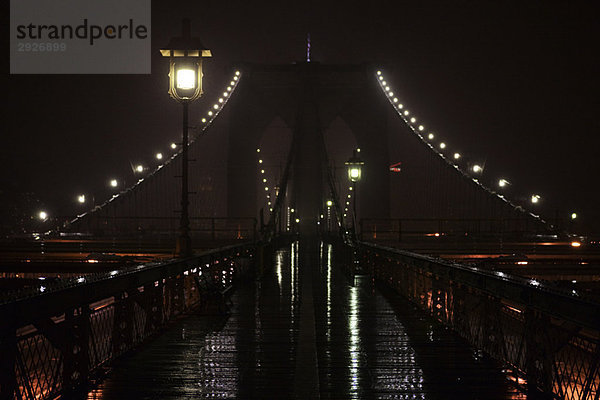 Erhöhter Fußgängerweg nass nach Regen bei Nacht  oberhalb der Brooklyn Bridge  New York City