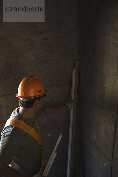 Bauarbeiter beim Einbringen von Holz in die Ecke