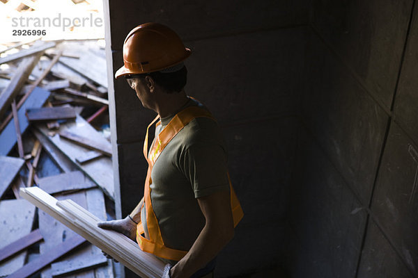 Bauarbeiter beim Transport von Altholz auf der Baustelle