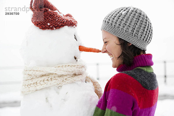 Frau Nase an Nase mit Schneemann