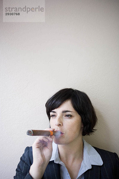 Geschäftsfrau beim Zigarrenrauchen