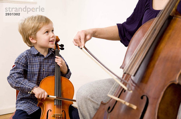 Frau und Junge spielen Cello