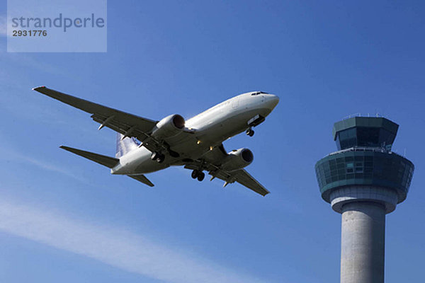 Flugzeug fliegt am Kontrollturm vorbei