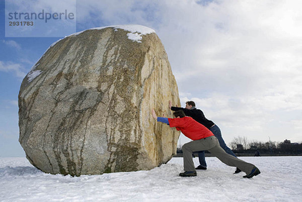 2 Männer schieben massive Felsbrocken