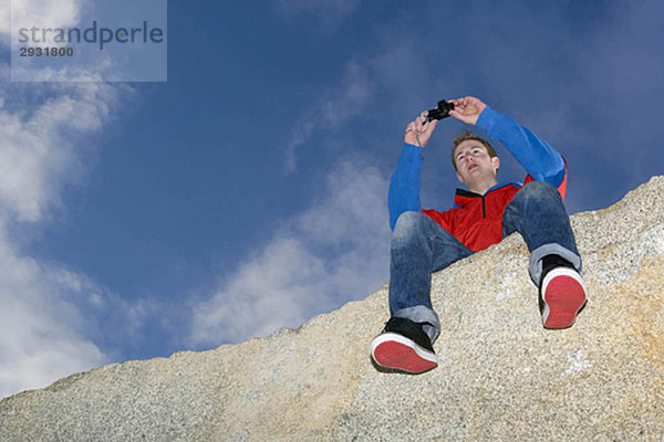 Mann beim Fotografieren auf dem Berggipfel