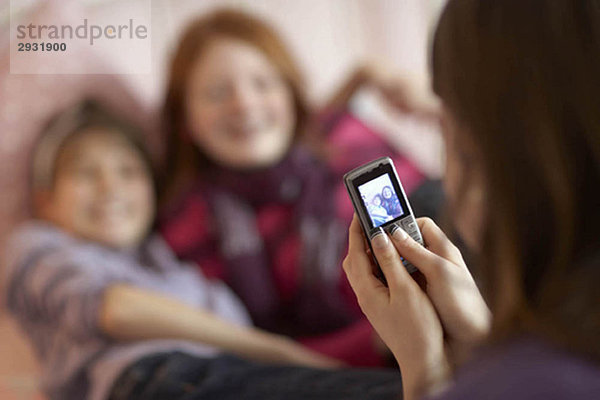 Teenagermädchen fotografieren am Telefon