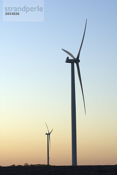 Two wind turbines at sunset