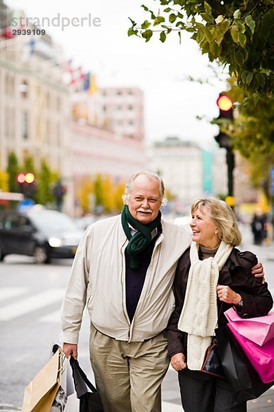 Ein älteres Paar tragen Tragetaschen Stockholm Schweden.