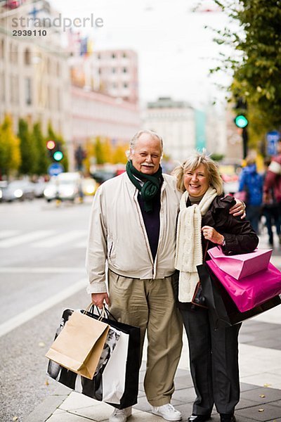 Ein älteres Paar tragen Tragetaschen Stockholm Schweden.