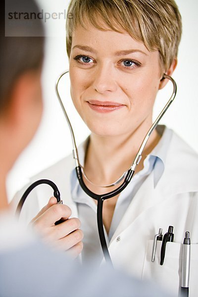 Eine Ärztin mit einem Blutdruck Messgerät Schweden.