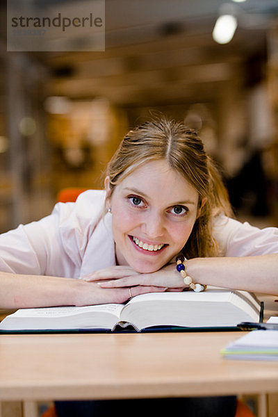 Ein weiblicher Student Studium in einer Bibliothek Schweden.