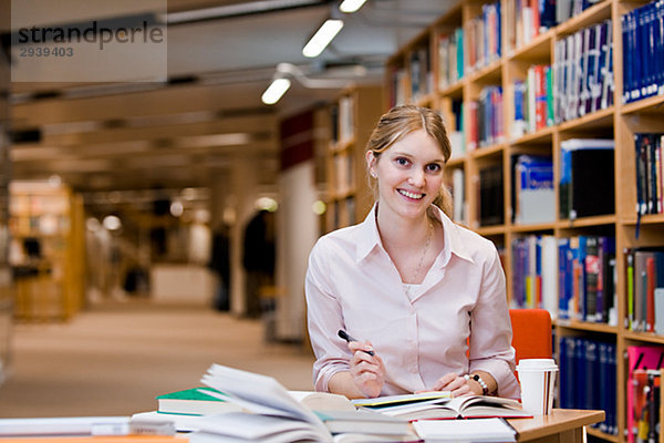 Ein weiblicher Student Studium in einer Bibliothek Schweden.