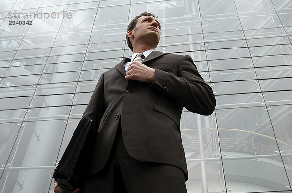 31-jähriger Business Mann im Anzug vor Glasfassade