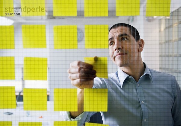 Mann beim Anbringen von Post-it