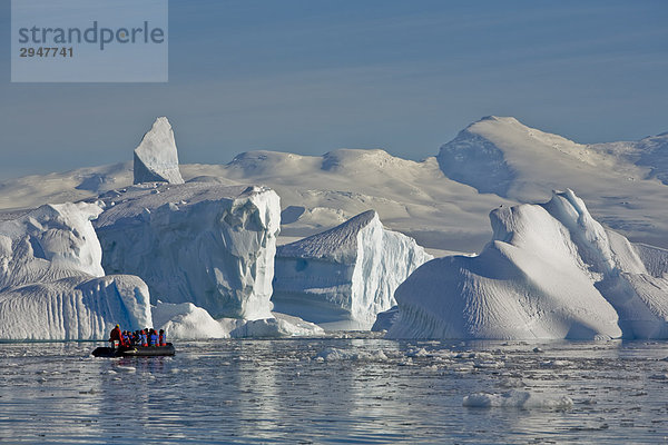 Reisende übergeben riesige Eisberge in der Wilhelmina-Bucht vor der Enterprise-Insel in der Antarktischen Halbinsel
