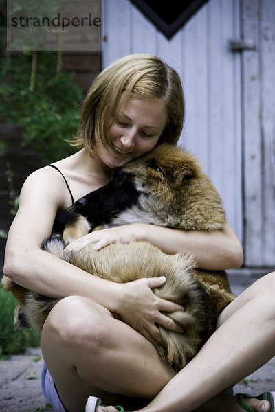 junge Frau hält ihres Hundes.