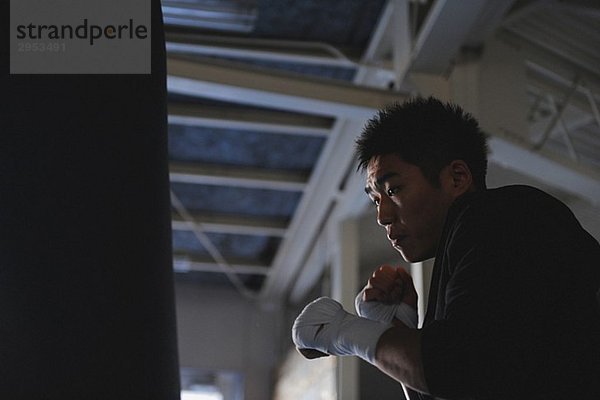 Japanischer Boxer üben mit Boxsack