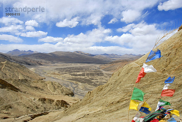 Blick in karges Tal mit bunter Gebetsfahne im Wind Shegar Tibet China